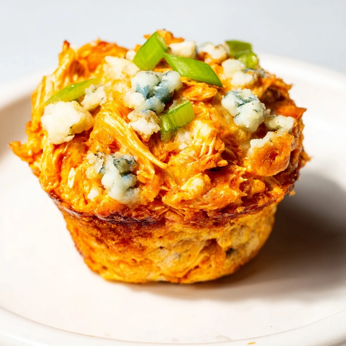 Spicy Buffalo Chicken Cheddar Drop Muffins topped with blue cheese for a flavorful finish.  