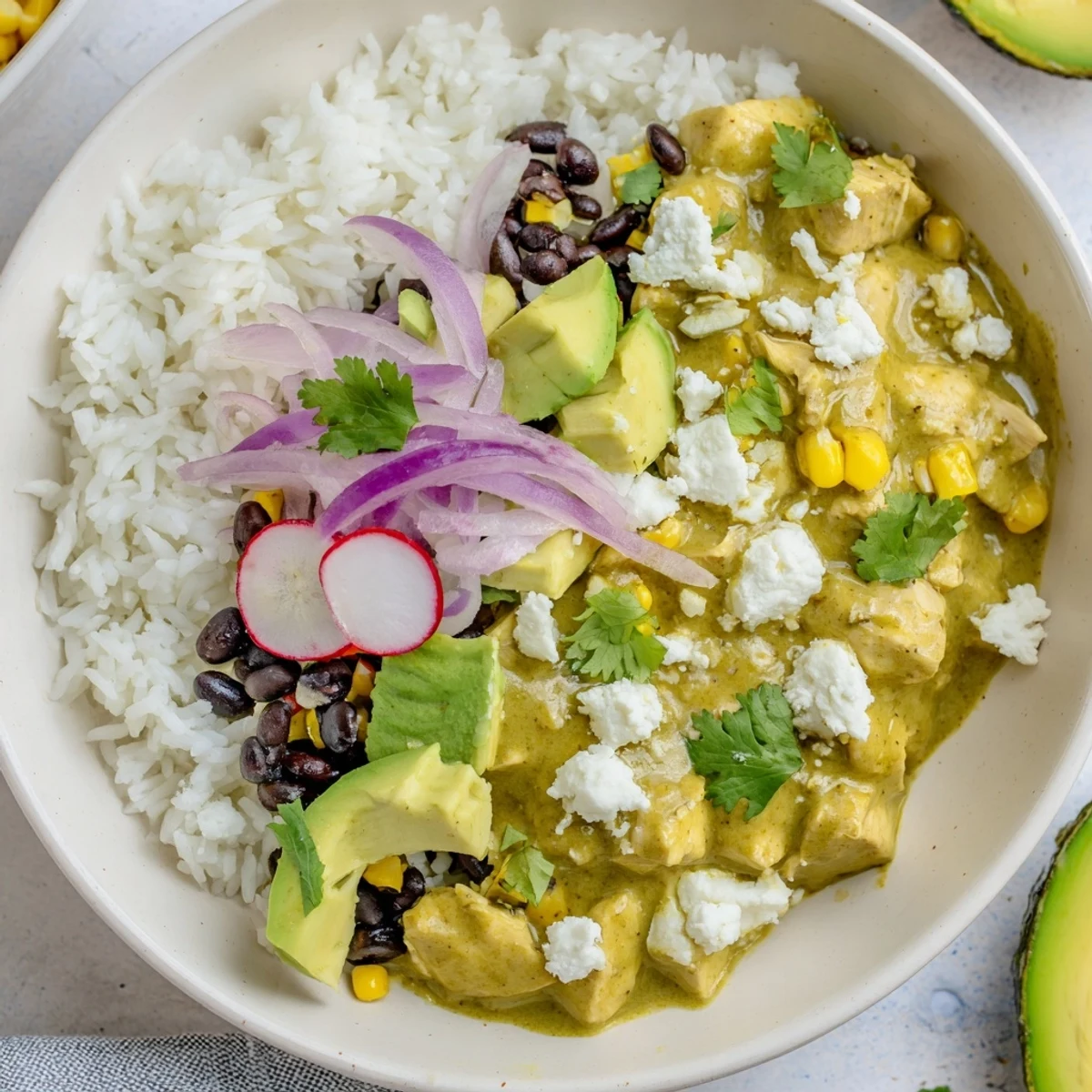 Green Enchilada Rice Bowl overflowing with chicken, rice, beans, and fresh vibrant toppings, ready to enjoy.