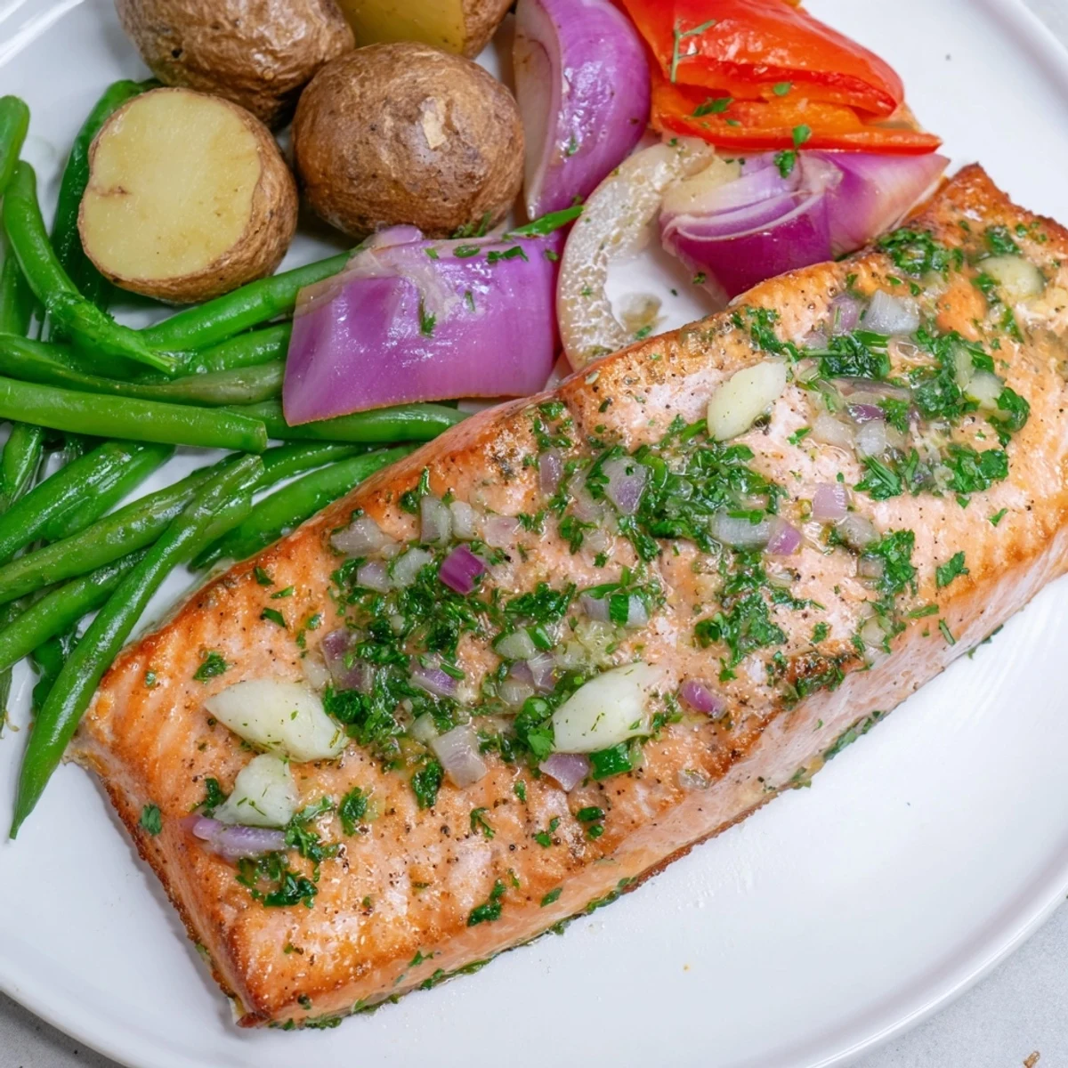 Golden, flaky Lemon Herb Salmon & Potato Sheet Pan with roasted potatoes and colorful vegetables.