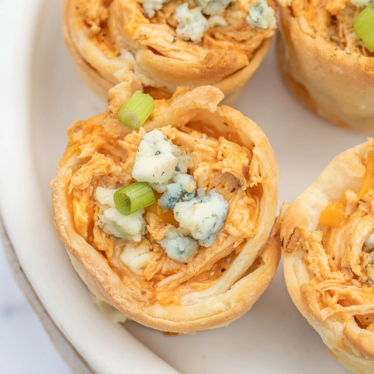 Golden-brown Buffalo Chicken Dip Pinwheel Wontons, a crispy appetizer ready for dipping in ranch.