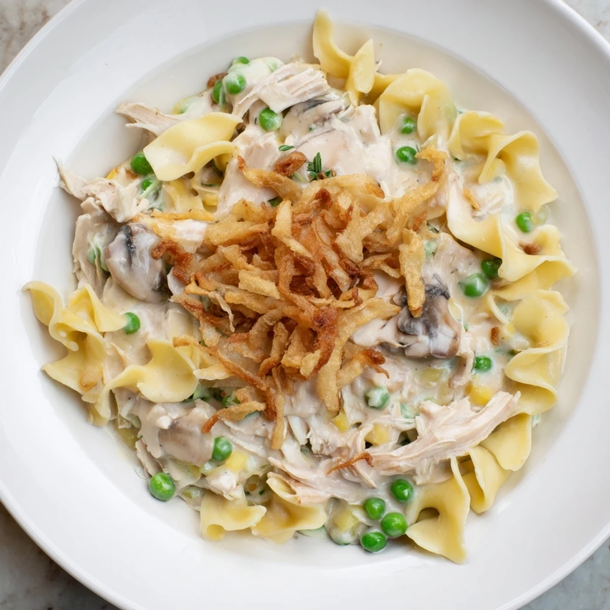 A bubbly Creamy Tuna Noodle Casserole with golden crispy onions, ready for a delicious, comforting meal.