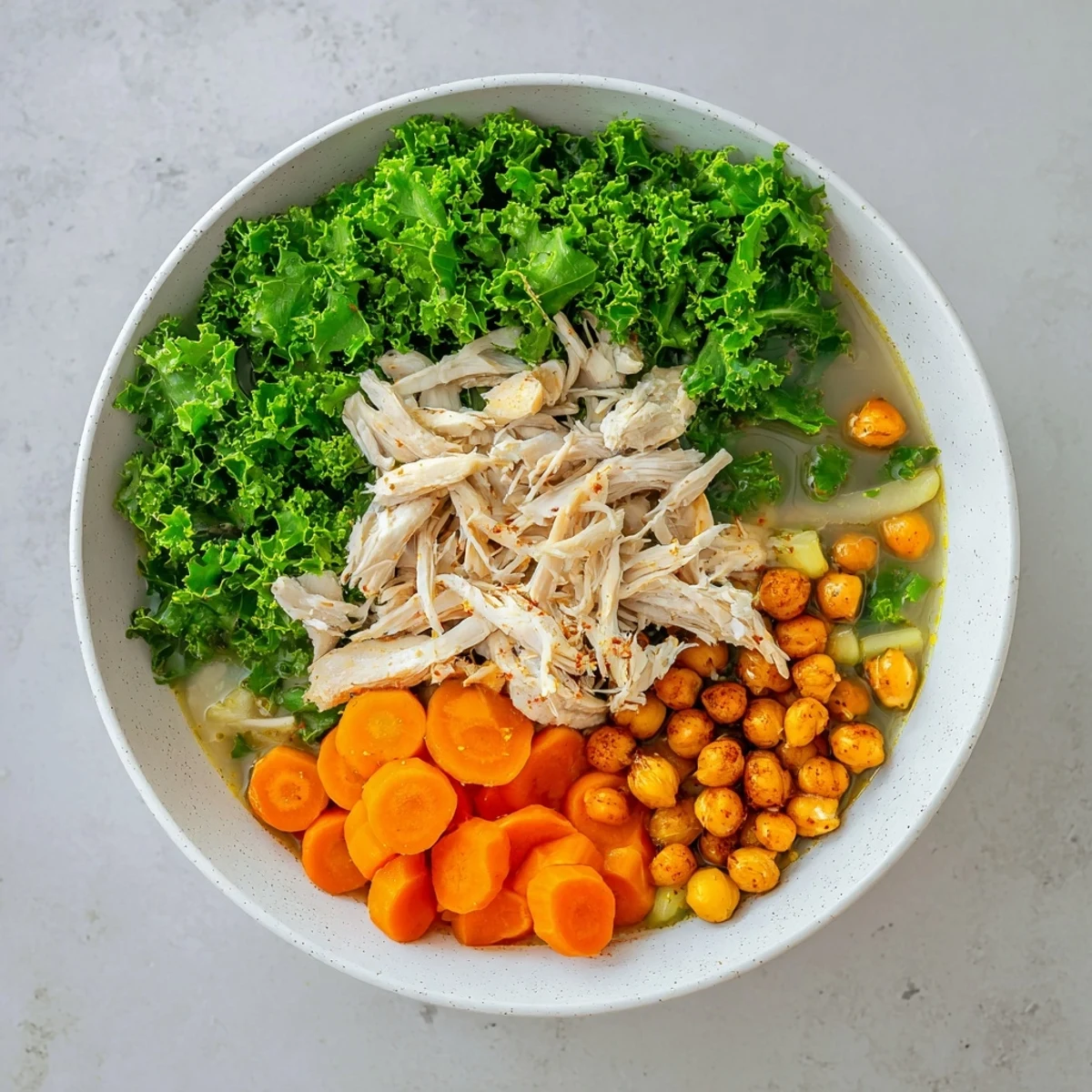 Chicken Kale Soup with Crispy Chickpeas, a warm bowl filled, topped with golden, crunchy chickpeas.