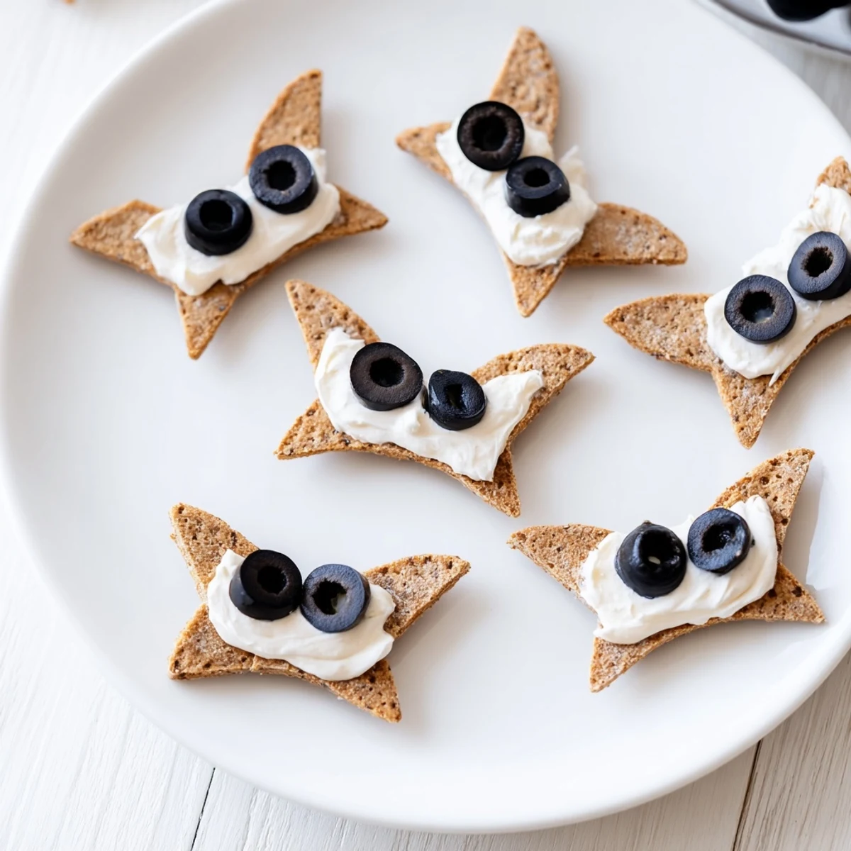 Festive Flying Bat Halloween Snack Board overflowing with crackers, cheese, and colorful vegetables.