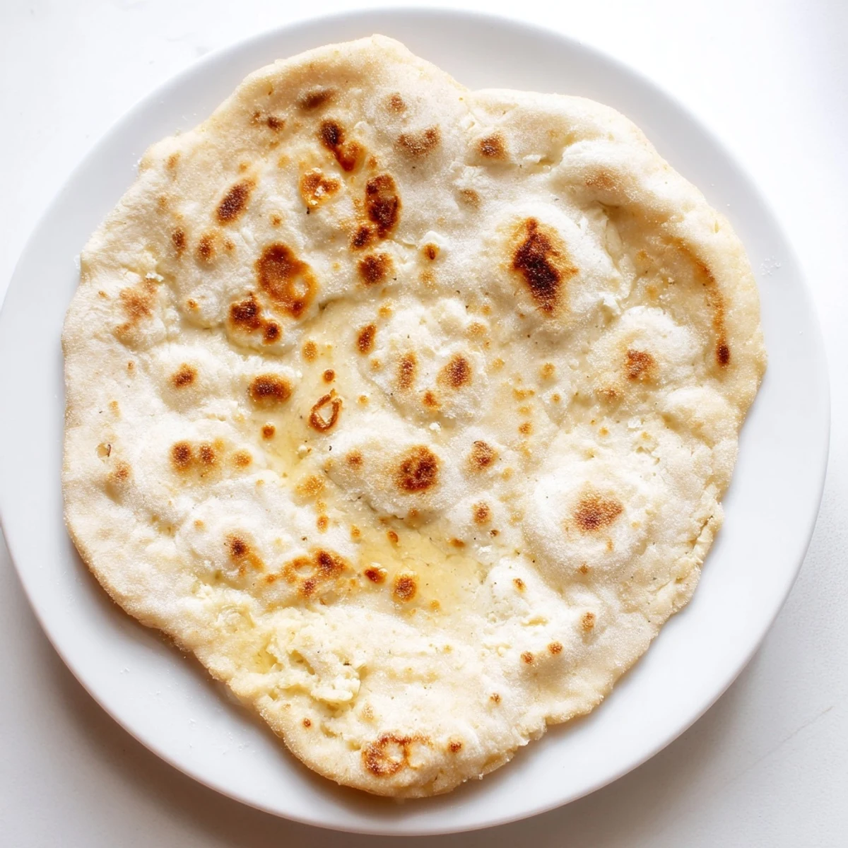 A stack of soft cottage cheese flatbread, perfect for dipping, with slightly charred edges and a tender texture.