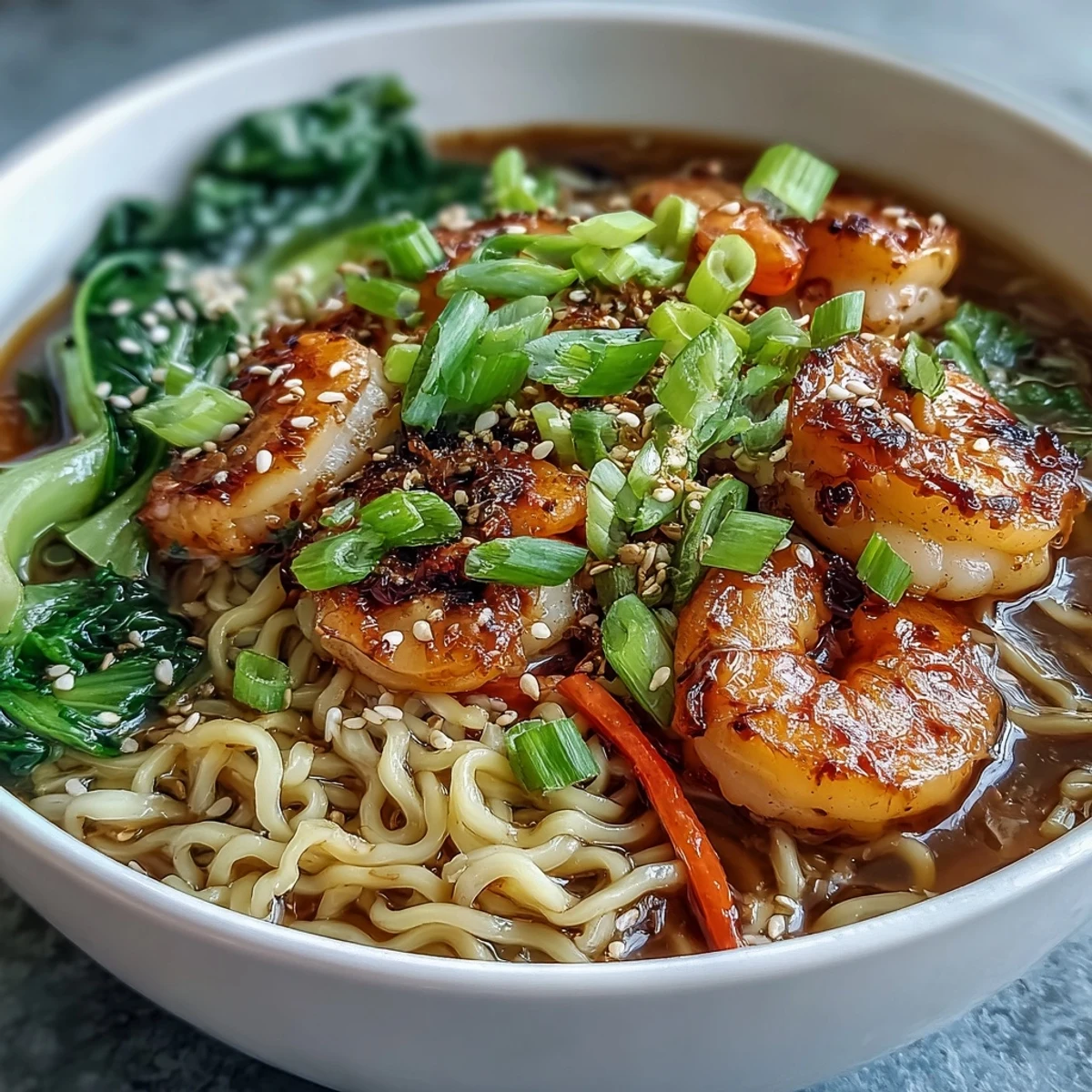 Steaming bowl of Asian Noodle Bowl with Shrimp and Scallops, featuring silky noodles, bok choy, and vibrant carrots in savory broth.  