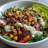 Golden roasted sweet potatoes and chickpeas shine in this wholesome, colorful bowl, garnished with fresh cilantro and creamy avocado.