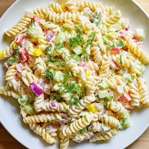 Creamy Dill Pickle Chopped Pasta Salad, loaded with crisp veggies and sharp cheddar cheese, looks refreshing.