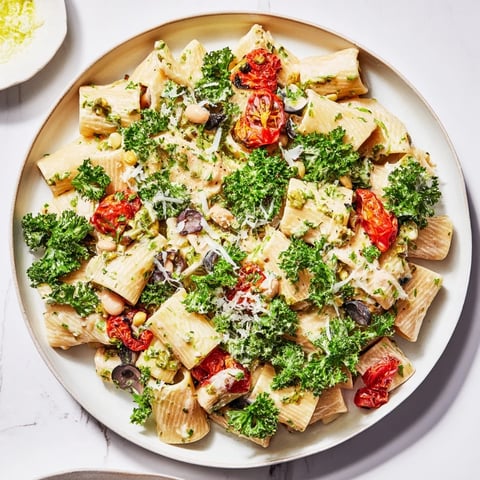 Steaming bowl of Healthy Tuscan White Bean & Kale Christmas Pasta, garnished with lemon zest, ready to savor.
