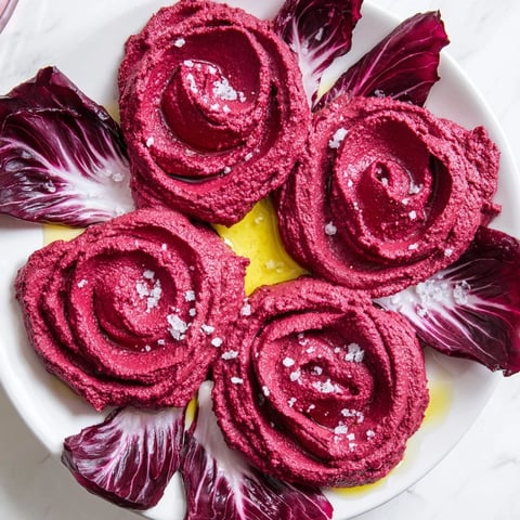 Vibrant The Velvet Rose appetizer: creamy beet hummus roses with crisp radicchio, ready to eat.