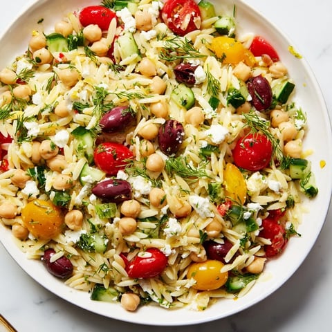 Bright Greek Lemon-Orzo Bean Salad featuring juicy tomatoes and tangy lemon dressing.
