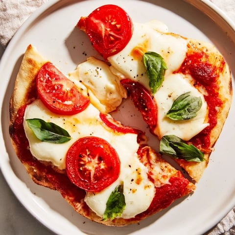 Quick Margherita Naan Pizza: Cheesy mozzarella and juicy tomatoes atop toasted naan, ready to eat.