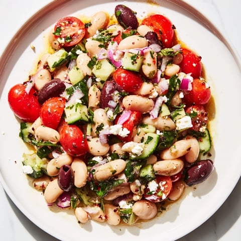 White bean salad brimming with colorful tomatoes, herbs, and a bright olive oil dressing.