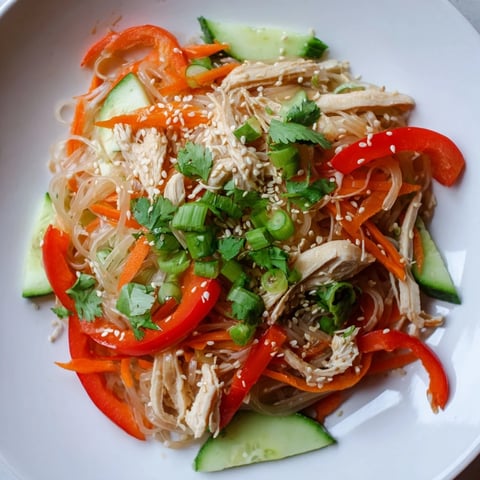 Chilled Chicken Noodle Salad: A vibrant bowl showcasing colorful veggies, tender chicken, and sesame dressing.
