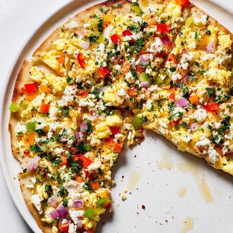 Golden-brown Turkish Menemen Eggs Pizza topped with creamy feta, fresh parsley, ready to eat.