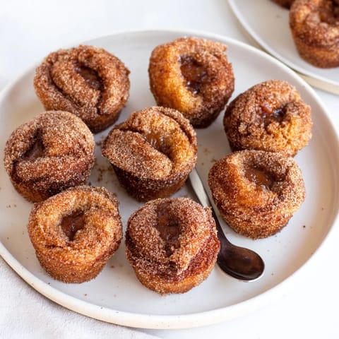 Homemade apple butter churro muffin bites freshly baked and rolled in sweet cinnamon sugar.  
