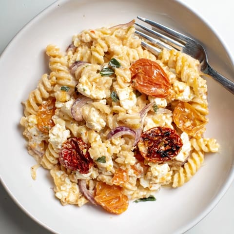 Delicious baked feta pasta dish, bursting with flavor and fresh basil garnish.  