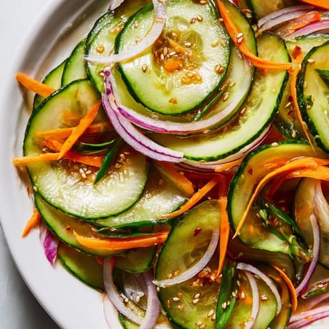 Colorful cucumber salad remix showcasing thinly sliced veggies and savory Asian flavors.  