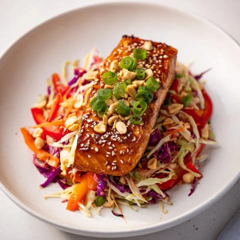A close-up of tender teriyaki salmon with a vibrant Asian slaw, ready to be enjoyed.