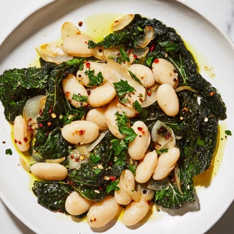 Hearty garlicky beans with winter greens, showcasing textures: creamy beans and tender greens.
