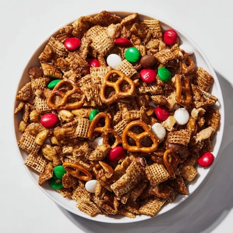 Golden-baked Holiday Mix, showcasing pretzels, Chex mix, and festive candies in a holiday bowl.