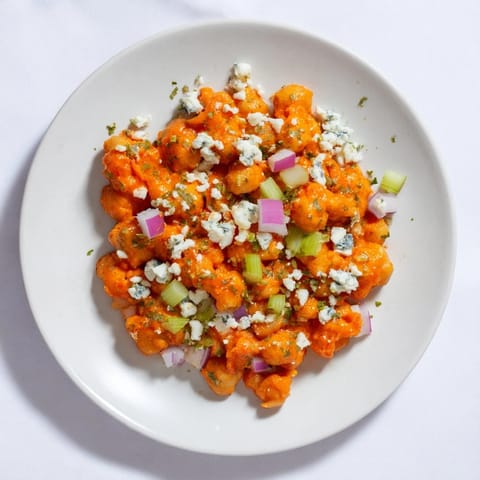 This colorful buffalo chicken bean salad features juicy chickpeas, crunchy vegetables, and zesty sauce.