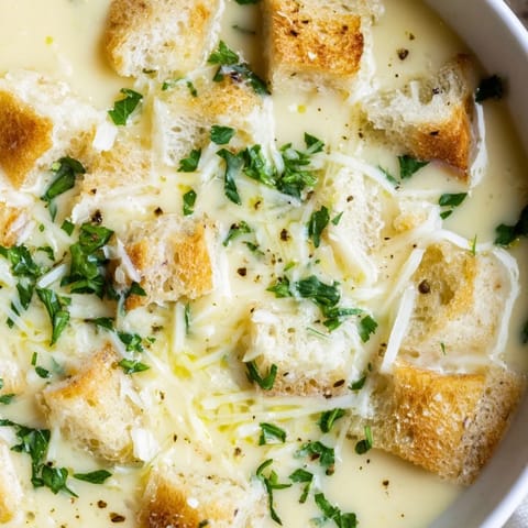 Warm, inviting bowl of creamy garlic bread soup with toasted bread croutons, ready to savor.