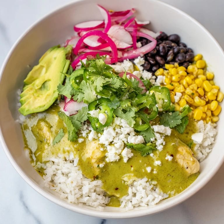 This hearty Green Enchilada Rice Bowl showcases its ingredients like fluffy rice, cheese, and avocado.