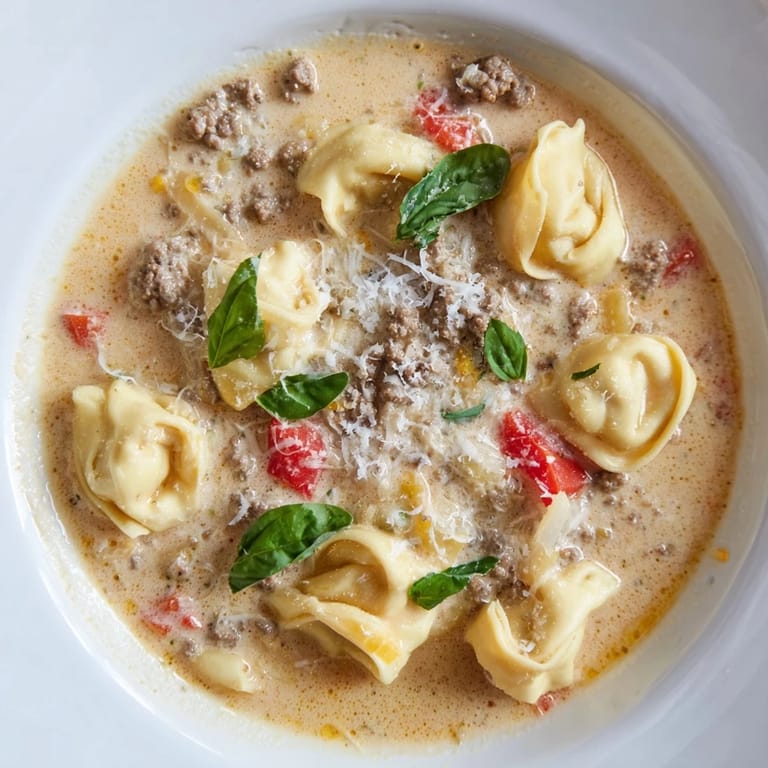 Enjoy a visually delicious view: rich Tortellini Beef Soup with ground beef and tomatoes, ready to serve.