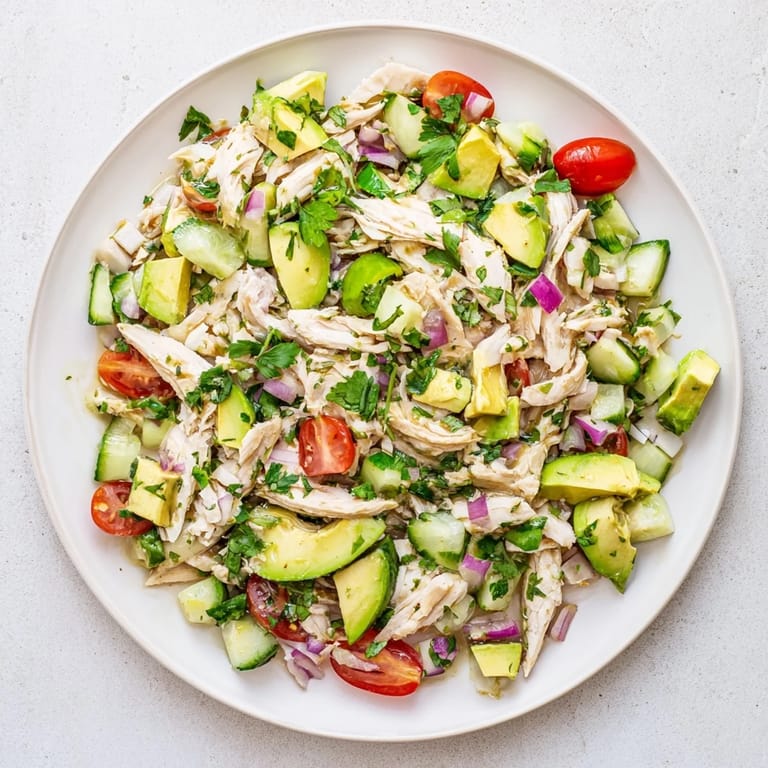 Healthy avocado chicken salad with tender chicken breast, lime dressing, and fresh herbs ready to serve.