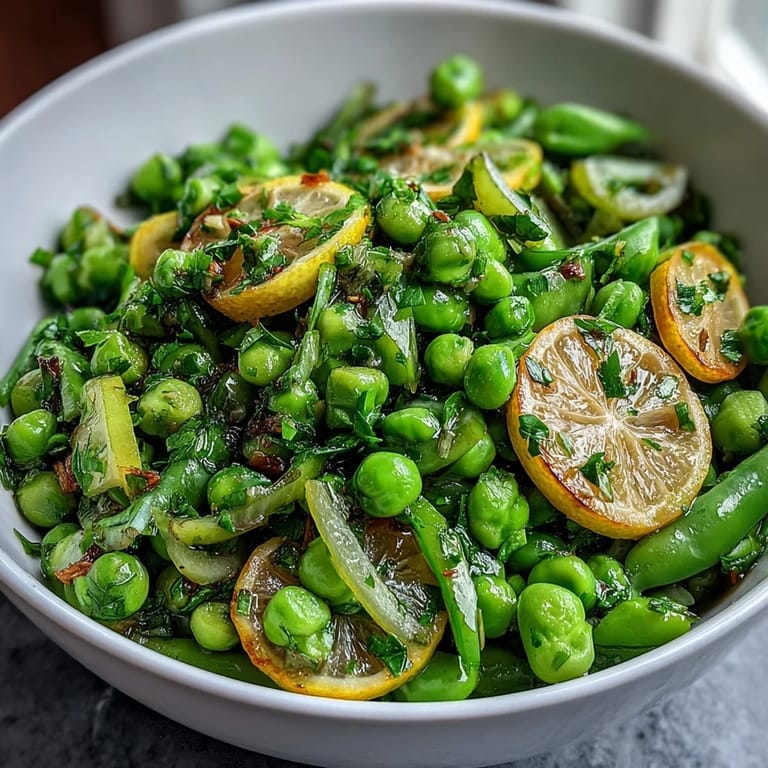 Zesty lemon vinaigrette coats vibrant spring salad with fresh radishes, peas, and mixed greens—a light, refreshing dish perfect for any meal.