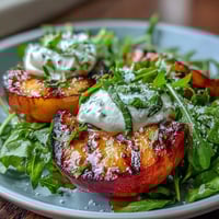 Juicy grilled peaches paired with creamy burrata cheese, drizzled with honey for a perfect summer salad.